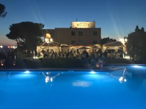 a swimming pool in front of a building at night at Hotel Holiday Sul Lago in Bolsena