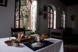 einen Tisch mit einem Teller Essen und zwei Fenstern in der Unterkunft Hiliki House in Zanzibar City