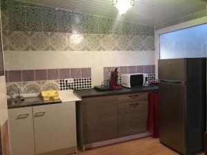 a small kitchen with a refrigerator and a microwave at Gite *Anzi* in Arcis-sur-Aube