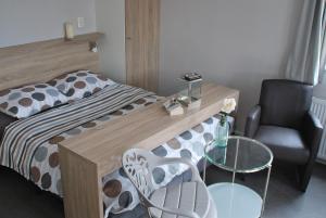 een slaapkamer met een bed, een tafel en een stoel bij Hotel Chalets Middelburg in Middelburg