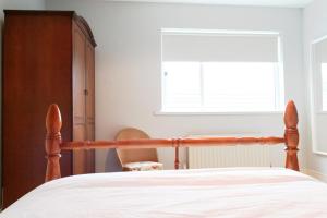 a bedroom with a bed and a chair and a window at Harbour Bar Apartment in Greencastle +16 photos