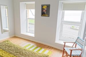 a living room with two windows and a couch at Harbour Bar Apartment in Greencastle