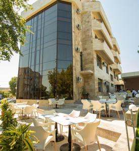 um pátio exterior com mesas e cadeiras em frente a um edifício em MSR Port Hotel em Mangalia