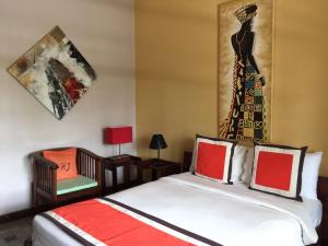 a bedroom with a bed with a dress on the wall at Hotel Joffre in Toamasina +32 photos