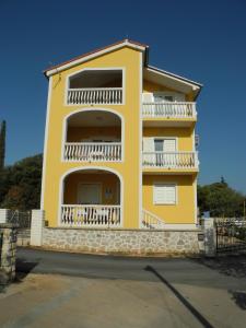 a yellow building with a balcony on the side of it at Villa Ines in Jezera