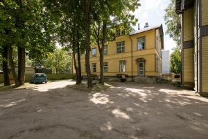 une maison jaune avec un arbre devant elle dans l'établissement Kalamaja Apartment, à Tallinn
