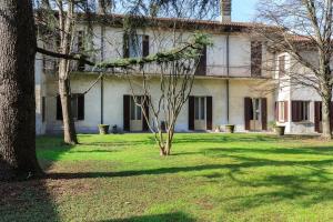 une vieille maison avec des arbres devant elle dans l'établissement Villa Mereghetti, à Corbetta