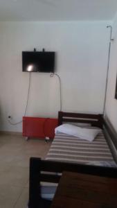 Zimmer mit 2 Betten und einem TV an der Wand in der Unterkunft Cabañas Punta Fabiana in Resistencia