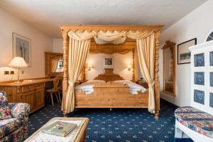 a bedroom with a wooden canopy bed in a room at Garni Criss in Colfosco