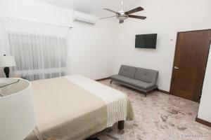 a bedroom with a bed and a chair and a ceiling fan at Hotel Casa Ortiz in Ciudad Valles