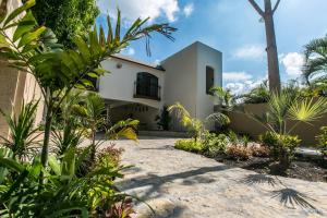 een wit huis met een palmboom en planten bij Hotel Casa Ortiz in Ciudad Valles