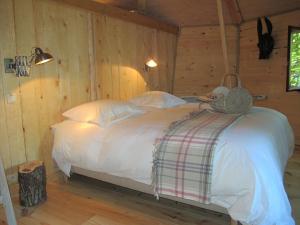 Een bed of bedden in een kamer bij B&B La Cabane du Bois Dormant