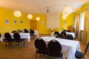 a conference room with tables and chairs and lights at Landgut Stetter in Schöllnach