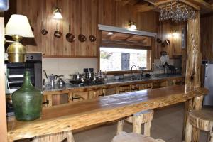 una cocina con una gran barra de madera con una botella verde en Casa del Lago en Villa Meliquina