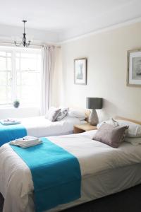 two beds in a room with white and blue at The Station in West Byfleet