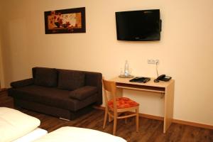 a living room with a couch and a table with a tv at Hotel Gasthof zur Post in Bärnau