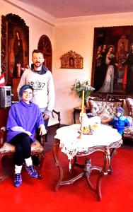 dos hombres parados en una sala de estar con una mesa en Fuente de Agua Hotel, en Cusco