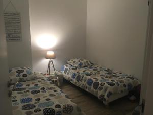 - une chambre avec deux lits et une lampe dans l'établissement Appartement Côté Bassin, à Andernos-les-Bains