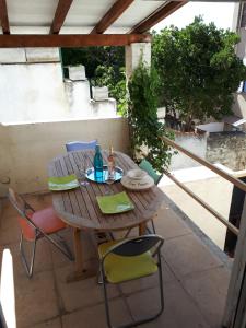 Une table et des chaises en bois sont disponibles sur la terrasse. dans l'établissement Maison de Ville, à Marseille