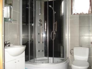 a bathroom with a shower and a toilet and a sink at Ośrodek Wypoczynkowy "Słoneczko" in Rusinowo