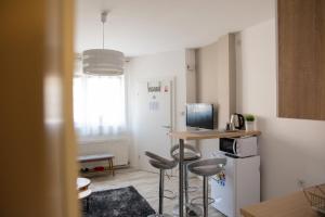 a small kitchen with a table and stools in a room at Apartment Impression in Osijek