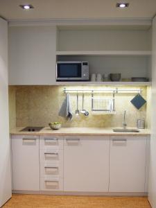 a kitchen with white cabinets and a microwave at Hall Chiado in Lisbon