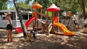 a woman standing in front of a playground at Villaggio Baia Dei Lombardi in Vieste