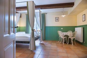 una camera con tavolo, sedie e letto di Quinz - Locanda Al Lago a Misurina