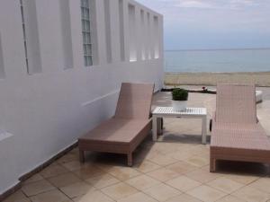 two chairs and a table on a patio near the beach at Marine House Andrianna -Adults only in Siviri