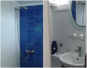 a blue tiled bathroom with a shower and a sink at Marine House Andrianna -Adults only in Siviri