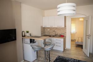 a kitchen with a counter and two stools in it at Apartment Impression in Osijek