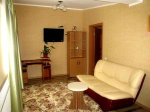 Apartment on Hoholya 90 في كرابينييتسكيه: غرفة معيشة مع أريكة بيضاء وطاولة