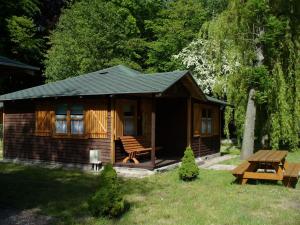 a small cabin with a picnic table and a bench at Camping Baltic in Kołobrzeg