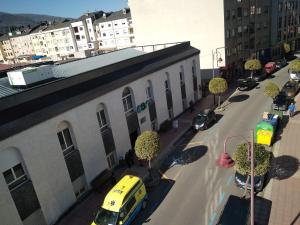 una furgoneta amarilla estacionada en una calle al lado de un edificio en Hostal Mayo, en O Barco de Valdeorras