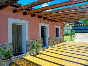 une terrasse couverte d'une maison avec une terrasse en bois dans l'établissement Los Sotillos De Gredos, à Arenas de San Pedro