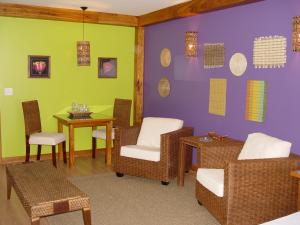 伊茹伊的住宿－Hotel Paradise，一间设有椅子和一张桌子的等候室,拥有紫色和绿色的墙壁