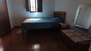 Dormitorio pequeño con cama y espejo en Quinta da Canastreira, en Cercal