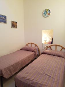 スペルロンガにあるCasa Sperlongaのベッドルーム1室(ベッド2台、壁に皿付)