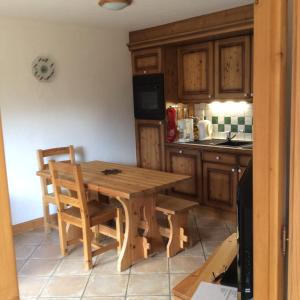 a kitchen with a wooden table and chairs at Facing the Chamonix Needles in Les Houches