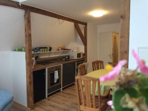 eine Küche und ein Esszimmer mit einem Tisch, einer Küche und einem Zimmer in der Unterkunft Ferienwohnung Waldsee in Waldsee