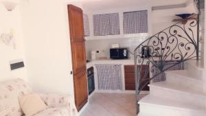 a living room with a staircase and a kitchen at Raffinato bilocale a Lido di Camaiore vicino al mare in Lido di Camaiore