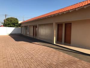 a building with a red roof and a brick driveway at Pousada LM in Nova América da Colina
