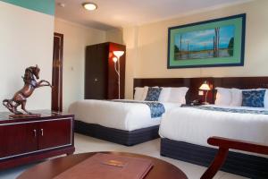 een hotelkamer met 2 bedden en een tafel bij Hotel Palacio in Paramaribo