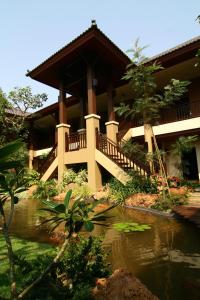 ein Haus mit einem Teich davor in der Unterkunft Mae Jo Golf Resort & Spa in San Sai