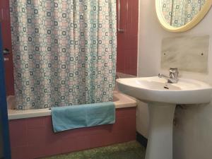 a bathroom with a sink and a shower curtain at Pension Casa Austria in Calella +104 photos