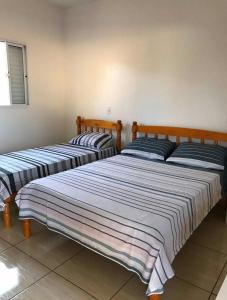 dwa łóżka siedzące obok siebie w pokoju w obiekcie Pousada LM w mieście Nova América da Colina