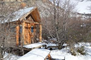 a log cabin in the snow with snow on it at Camping Rio de las Vueltas in El Chalten