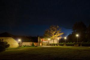 una casa por la noche con un árbol en el patio en Smeceres krogs, en Madona