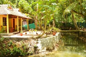 a house with a pond in front of a house at Munroe Nest Homestay in Munroe Island