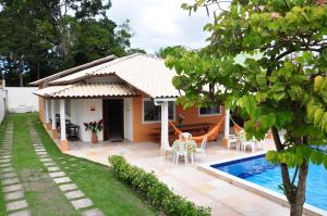 a house with a swimming pool in front of it at Recanto do Village in Porto Seguro